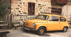 Macchina gialla davanti a casa in mattoni